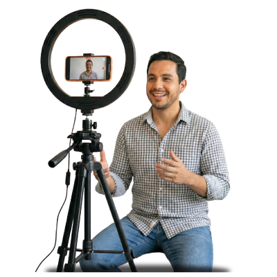 Profesional grabando contenido para redes sociales con celular y aro de luz, autogestión de redes sociales